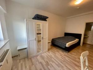 a bedroom with a bed and a white cabinet at Appartement im Zentrum von Baienfurt in Baienfurt