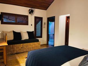 een slaapkamer met een bed, een bank en een raam bij The Barra Grande Guesthouse & Hostel in Barra Grande