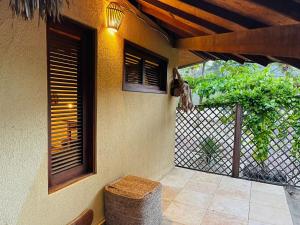 een veranda van een huis met een hek en een kruk bij The Barra Grande Guesthouse & Hostel in Barra Grande