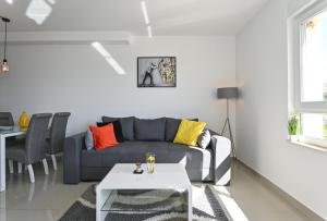 een woonkamer met een bank en een tafel bij Apartment TRI MASLINE in Trogir