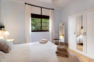 a white bedroom with a bed and a window at La Huerta in Hermigua