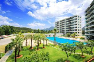 a resort with a large swimming pool and palm trees at The Sea Condominium A16 @ Dophin Bay, Pranburi in Ban Nong Khaem