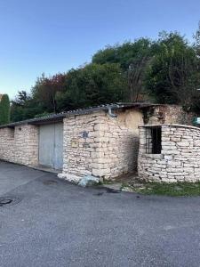 ein Steingebäude mit einer Seitentür in der Unterkunft La maison de Mounette in LʼIsle-dʼAbeau