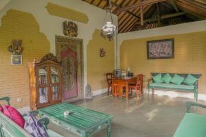 uma sala de estar com um sofá e uma mesa em Villa Chempaka em Ubud