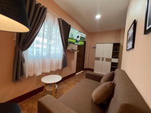 een woonkamer met een bank en een tv bij PePi-Resort in Chiang Rai