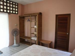 - une chambre avec un lit et un ventilateur dans l'établissement Cocohut Garden, 