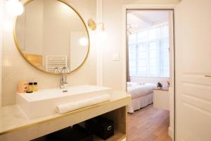 a bathroom with a sink and a mirror at Les Suites Faidherbe in Lille