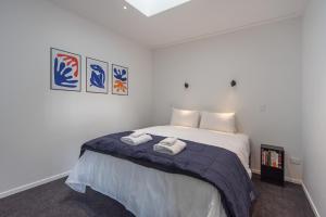 1 dormitorio con 1 cama con 2 toallas en Inner City Apartments - 1 en Nelson