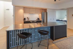 una cocina con barra y dos taburetes. en Inner City Apartments - 1 en Nelson