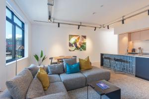 sala de estar con sofá y cocina en Inner City Apartments - 1, en Nelson