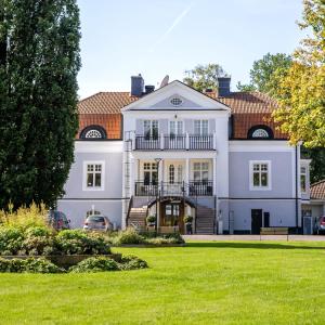 une grande maison blanche avec une grande cour dans l'établissement Starby Spa, Hotell & Konferens, à Vadstena