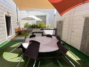 una mesa y sillas en un patio con sombrilla en شاليه ڤيو VIEW Chalet, en Sowayma