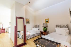 um quarto com 2 camas e um espelho em Admiralty Bed & Breakfast em Muizenberg