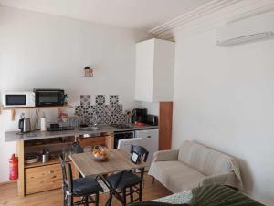 a living room with a table and a kitchen at La Dolce Vita Studio indépendant avec terrasse in Vals-les-Bains