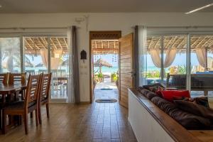 salon z kanapą i stołem w obiekcie Beachfront Villa Thamani with Private Pool and Beach ZanzibarHouses w mieście Pwani Mchangani