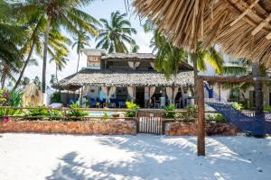 un complexe avec un hamac dans le sable et les palmiers dans l'établissement Beachfront Villa Thamani with Private Pool and Beach ZanzibarHouses, à Pwani Mchangani