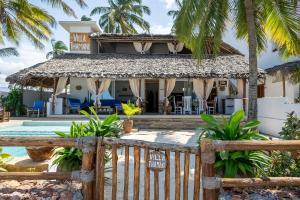 a house on the beach with a fence at Beachfront Villa Thamani with Private Pool and Beach ZanzibarHouses in Pwani Mchangani