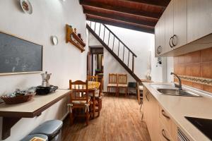 cocina con fregadero, mesa y escalera en Casa de Telégrafos, en Vallehermoso