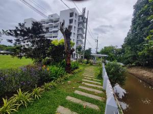 a walkway next to a building next to a river at Rua Rasada Express in Trang