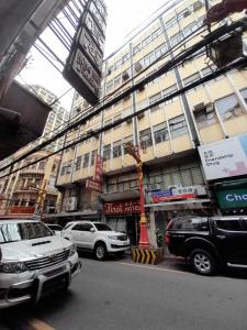 a city street with cars parked in front of a building at OYO 1011 First Hotel in Manila