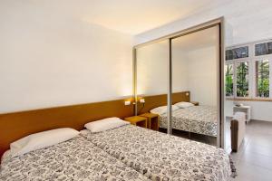 a bedroom with two beds and a mirror at Paraiso del Molinero Bajo in Mogán
