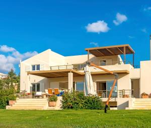 a house with a lawn in front of it at Legrena Beach Villa in Sounio