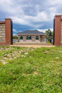 a building with a grass field in front of it at Homely Escapes in Nanyuki