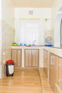 a kitchen with wooden cabinets and a trash can at Homely Escapes in Nanyuki