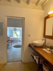 ein Bad mit einem Waschbecken und ein Zimmer mit einem Bett in der Unterkunft La Villa Trocas in Koungou