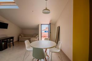 a dining room with a table and chairs in a room at La Scivola Rooms in Acitrezza