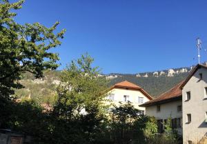a white building with trees and mountains in the background at À l'étape rêvée, charme, calme et nature in Baulmes
