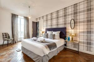 a bedroom with a large bed with two towels on it at Sweet Inn - Rue de Rivoli in Paris