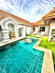 a swimming pool in the yard of a house at Pattaya Jomtien Private Luxury Pool Villa 芭堤雅中天豪华私家泳池别墅 in Jomtien Beach