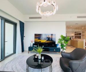 ein Wohnzimmer mit einem TV, einem Tisch und Stühlen in der Unterkunft 3BR, Burj Khalifa,Fountain48 in Dubai