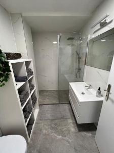 a white bathroom with a shower and a sink at Romantický úkryt s krbem v centru Prahy in Prague