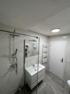 a white bathroom with a sink and a mirror at Romantický úkryt s krbem v centru Prahy in Prague