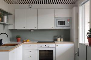 a kitchen with white cabinets and a stove top oven at Kodikas juuri remontoitu yksiö keskustassa in Hämeenlinna