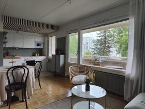 a kitchen and a living room with a table and chairs at Kodikas juuri remontoitu yksiö keskustassa in Hämeenlinna