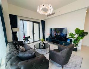 ein Wohnzimmer mit Ledersofas und einem Flachbild-TV in der Unterkunft 3BR, Burj Khalifa,Fountain48 in Dubai