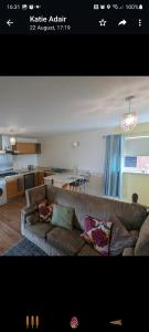 a living room with a couch and a kitchen at peaceful one bedroom apartment in Antrim