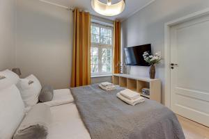 a bedroom with a bed with towels on it at Downtown Apartments Old Town Chlebnicka in Gdańsk