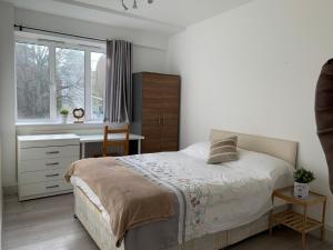 a bedroom with a bed and a desk and a window at Central London Maida Vale 4 or 5 bed spacious apartment in London