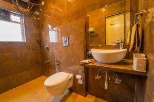 a bathroom with a sink and a toilet and a mirror at Polsburg Panchgani in Panchgani +48 photos