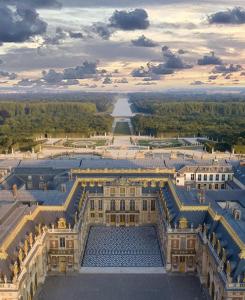 una vista aérea de un gran edificio con un puente en Les Mansardes du Roi en Versailles