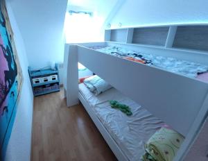 białe łóżko piętrowe w sypialni dla dzieci w obiekcie Le Cocon Croisicais - Les Gîtes de la Côte d'Amour w mieście Le Croisic