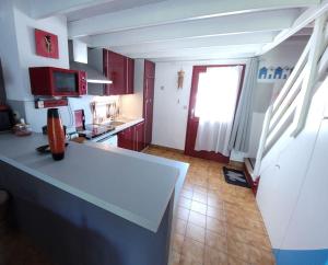 uma cozinha com armários vermelhos e um balcão branco em Le Cocon Croisicais - Les Gîtes de la Côte d'Amour em Le Croisic