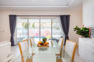 a dining room with a glass table and chairs at Winter Home Villa Huahin in Cha Am