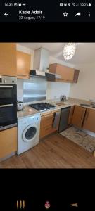 a kitchen with a stove and a washing machine at peaceful one bedroom apartment in Antrim