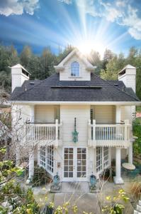 a white house with a balcony and the sun at The Bergson in Calistoga