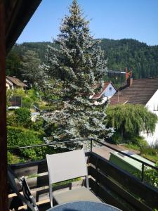 ein Weihnachtsbaum auf einem Balkon mit einem Tisch und einem Stuhl in der Unterkunft Haus Rebberg in Wolfach